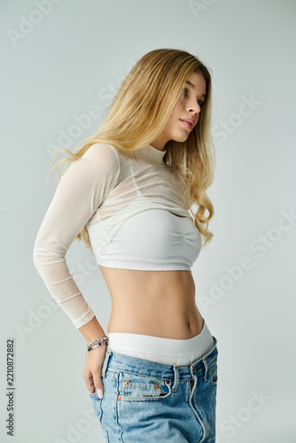Modern fashion elegance exuded by a young woman in light attire against a subtle backdrop
