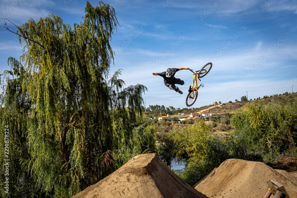 Obraz premium Dirt bike rider jumping on a dirt track in Arripiado village by the Tagus River, Portugal