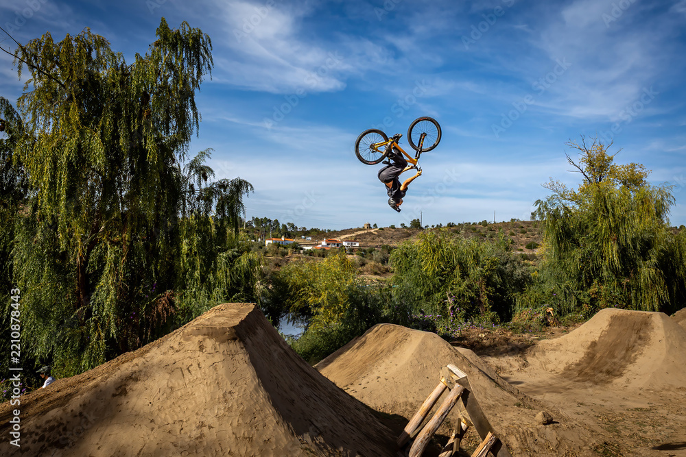 Obraz premium Dirt bike rider jumping on a dirt track in Arripiado village by the Tagus River, Portugal