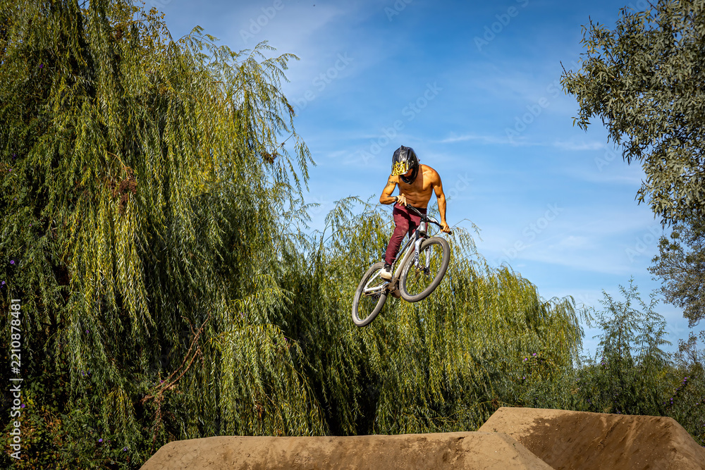 Obraz premium Dirt bike rider jumping on a dirt track in Arripiado village by the Tagus River, Portugal