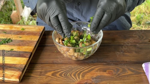 Pickled button mushrooms in a bowl are sprinkled with chopped herbs. High quality 4k footage