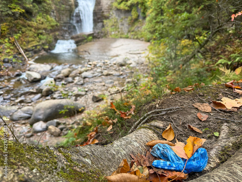 Pollution de l'environnement avec un sac de merde de chien laissé à côté d'un arbre dans la forêt	