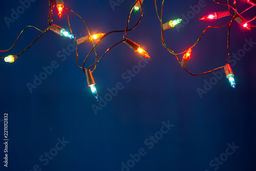 Christmas lights string on blue background with copy space