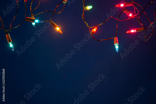 Christmas lights string on blue background with copy space