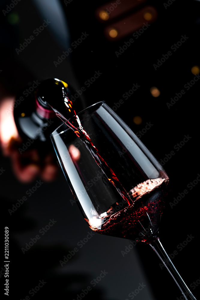 Obraz premium Premium Pinot Noir red wine with sommelier — decanting process in dark cellar. Exclusive food pairing preparation for luxury dinner. High quality alcoholic beverage featuring deep ruby color.