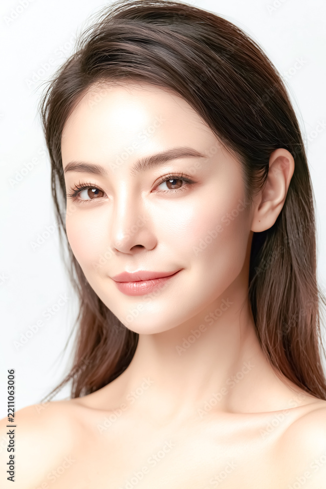 Fototapeta premium Young Asian woman touching her glowing skin creates a soft, elegant skincare visual ideal for beauty branding, wellness campaigns, and cosmetic advertising.