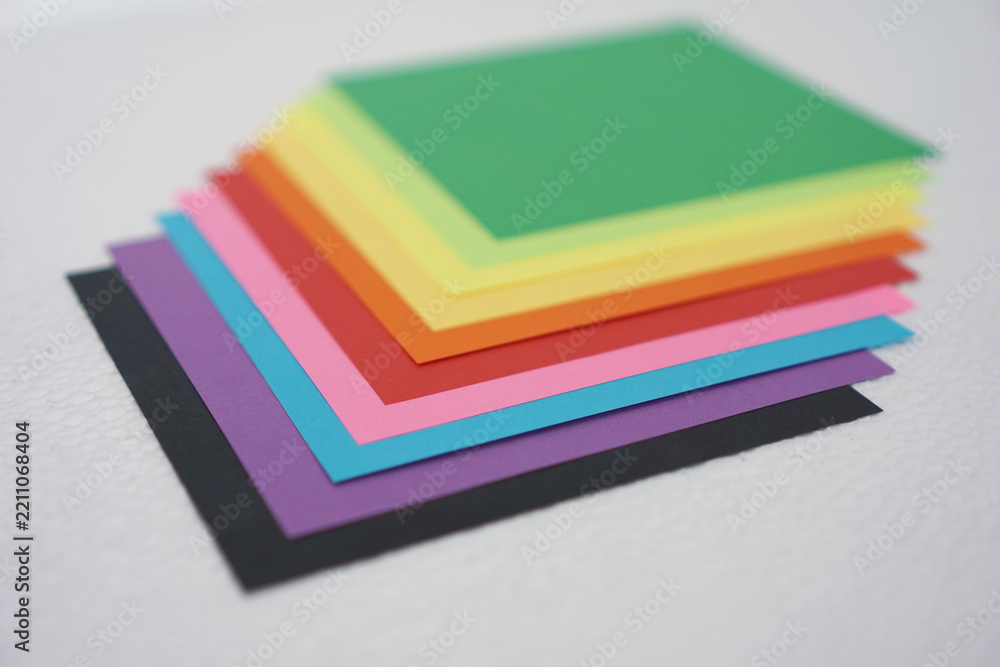 Fototapeta premium Colorful paper also known as colorful origami paper, is neatly arranged against a white background.
