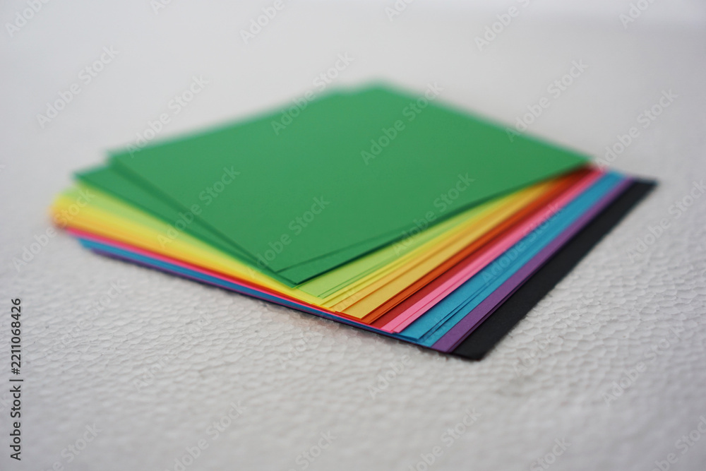 Fototapeta premium Colorful paper also known as colorful origami paper, is neatly arranged against a white background.