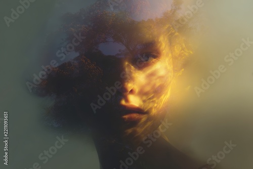 Surreal double exposure portrait merging a female face with tree canopy and light for conceptual background and environmental design