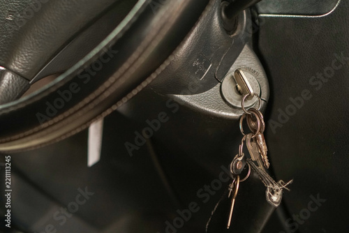 Car ignition key inserted in the switch inside a vehicle cabin