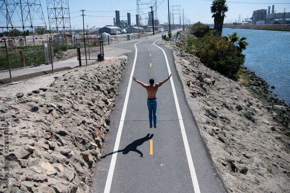 Obraz premium Freedom and happiness concept. Man jumping on road. Success and energy. Motivation lifestyle. Man freedom outdoors. Motivation and balance. Man with open arms jump outdoors. Victory and success.