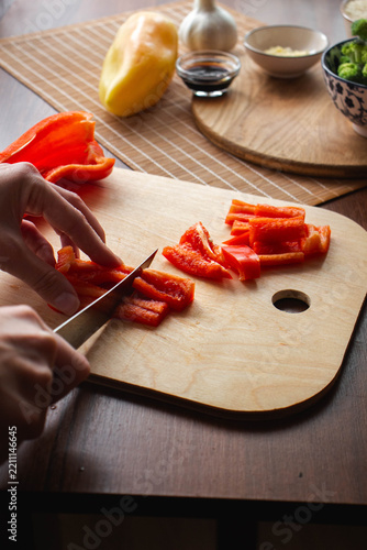 Slicing fresh red pepper for meal preparation in the kitchen