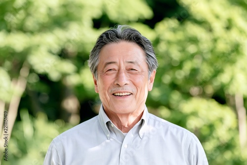 屋外で健康的な笑顔を見せる日本人シニア男性の明るいポートレート