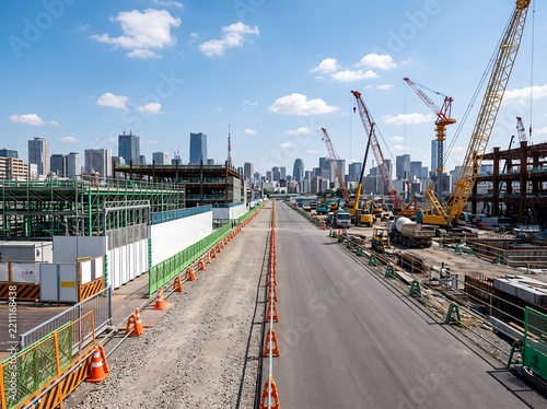 Obraz na płótnie 都市開発が進む工事現場でクレーンが動く日中の風景