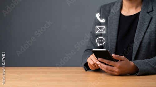 Business professional holding smartphone with floating contact icons for phone, email, and chat