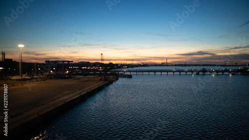 Industrial pier at sunset over calm harbor water freight distribution