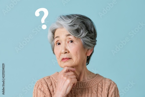 疑問を抱き何かを考え込むシニア女性の姿