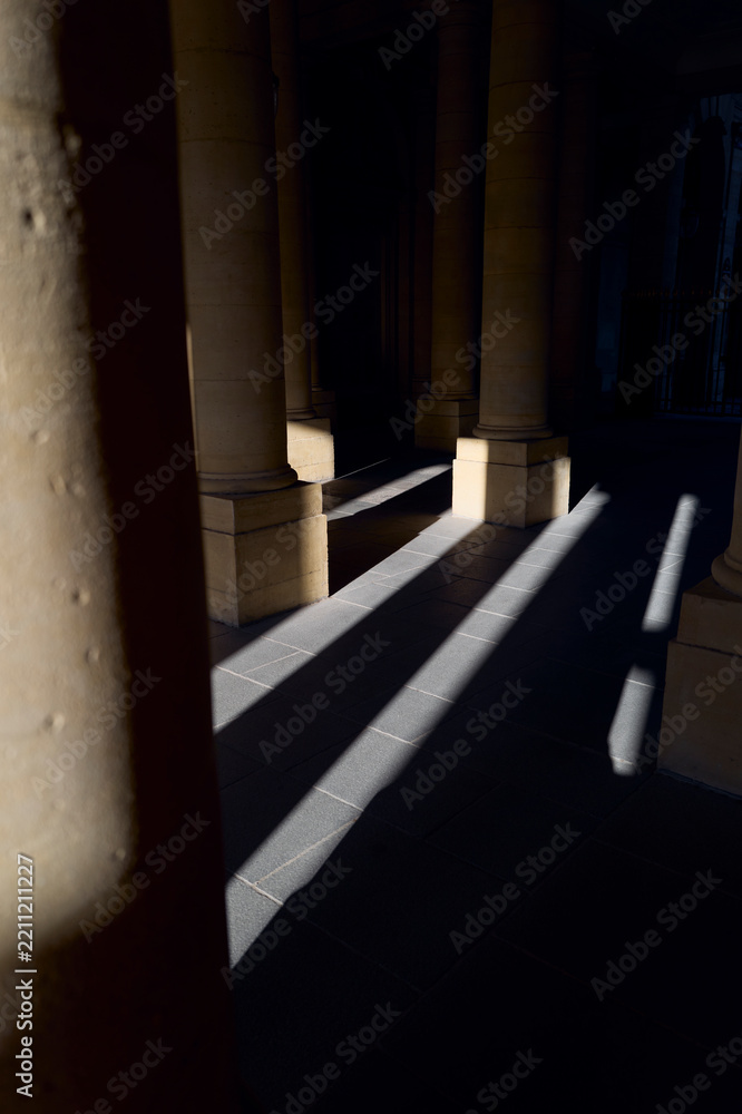 Obraz premium Sunlight creates dramatic shadows in a stone corridor