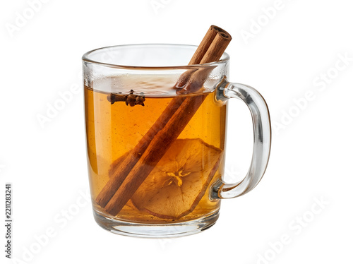 Hot spiced apple cider in clear glass mug with cinnamon sticks and star anise isolated on white.