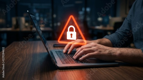 Hands typing on a laptop with a digital padlock overlay symbolizing security alert.
