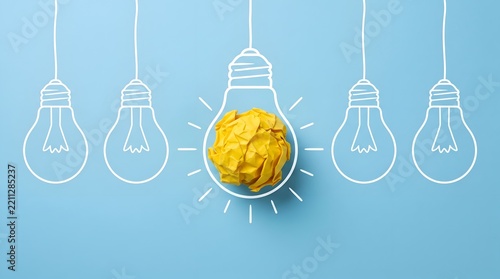 Creative Idea and Innovation Concept with One Yellow Crumpled Paper Lightbulb Standing Out on Blue Background