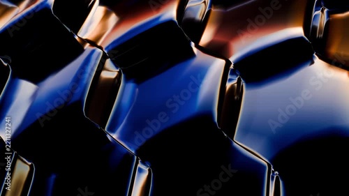 Close-up view of rotating glossy blue hexagonal surfaces