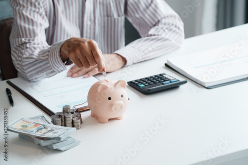 Close Up Business man Hands Saving Cash in Piggy Bank to Build Personal Bank Fund and Prepare for Future Financial Goals
