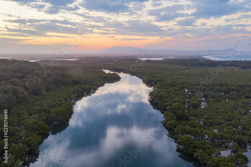 Aerial view along Back Creek at South West Rocks, New South Wales, during sunset, with calm water reflecting the colourful evening sky and surrounding mangrove landscape.
