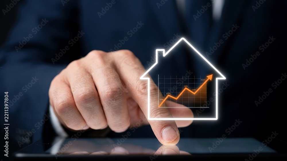 © Sanaullah - Businessman touching tablet screen showing real estate house icon with financial growth chart inside