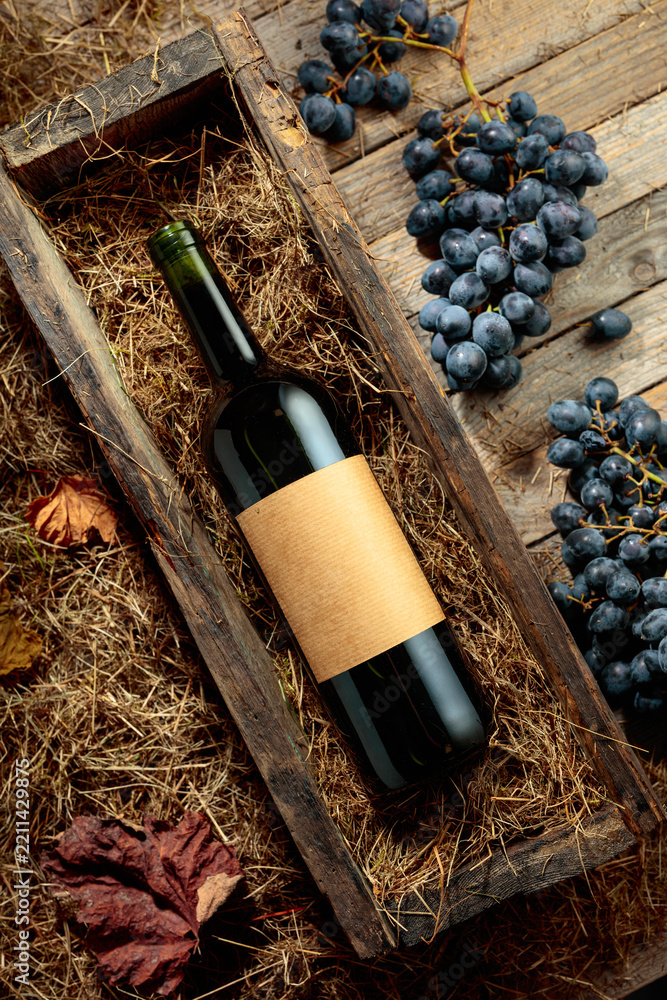 Obraz premium Bottle of red wine in an antique wooden box.