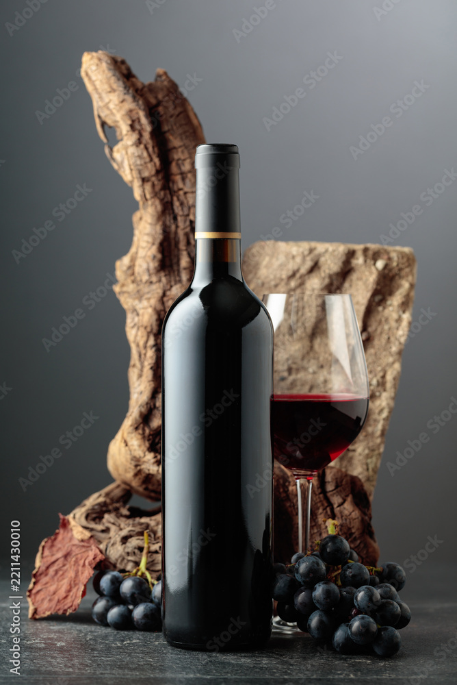 Obraz premium Red wine with stone, dried snags, and blue grapes.