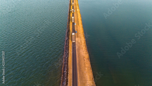 Aerial view of the Road to Heaven, a long straight road stretching through the salt flats of the Rann of Kutch with vehicles driving along the causeway in Bhuj, Gujarat, India.