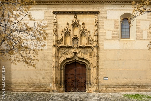 Granada's Royal Chapel entrance featuring intricate Isabelline Gothic architectural details with an ornate carved stone doorway and historic wooden doors