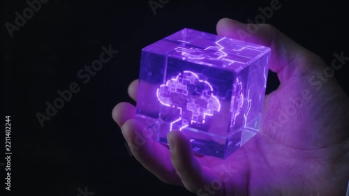 Futuristic technology video concept of hand holding a glowing holographic purple cloud computing cube