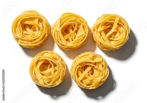 Five Nests Of Dry Tagliatelle Pasta Arranged On White Background
