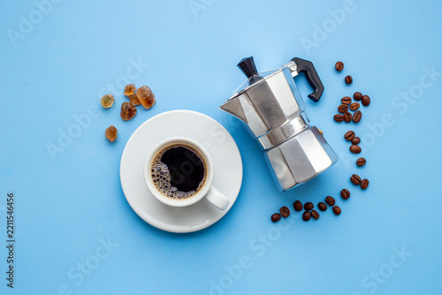 Fresh black coffee brewed in moka pot with coffee leaves - natural coffee experience and morning ritual, top view