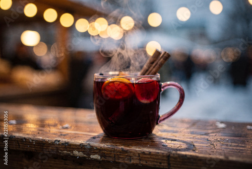 Steaming Mulled Wine with Cinnamon and Orange Slices on a Wooden Table during Winter.