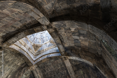 Ancient stone vault featuring ribbed arches and an octagonal skylight pouring soft light into a historic Haghpat Monastery built between the 10th and 13th century also known as Haghpatavank, Armenia