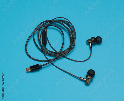 Black wire sports earphones on blue background