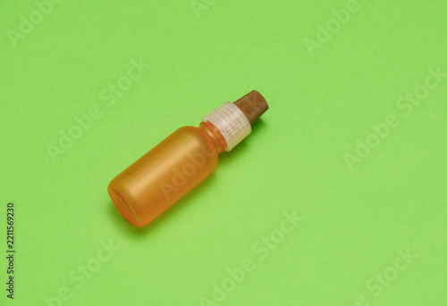 Small plastic dropper bottle on green background