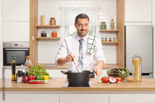 Man cooking a meal in a pot with a wooden spoon