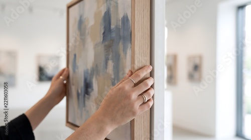 Woman holding an abstract painting in a modern art gallery interior