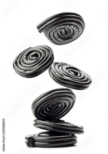 Liquorice candy wheels jumping, isolated on white background.