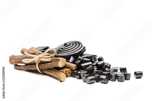 Liquorice candy wheels bunch with liquorice roots, isolated on white background.