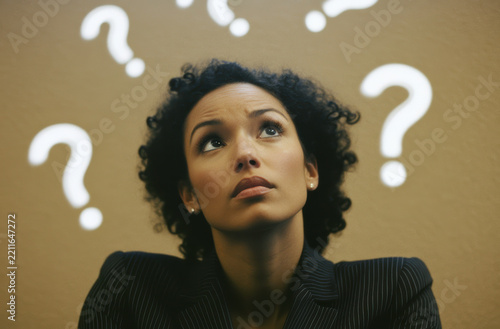 Woman looking up with question marks in background
