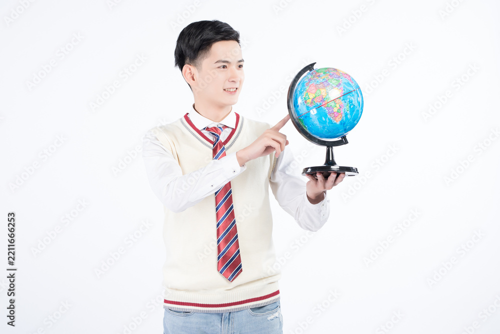 Fototapeta premium Smiling Student Holding and Pointing at a Globe in Uniform