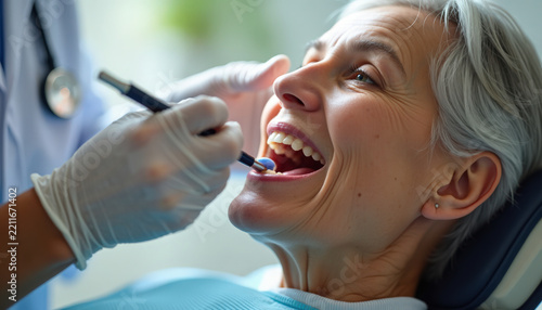 Dental examination with senior woman smiling during checkup by dentist in clinic. Dental care involves thorough checkup and cleaning for healthy teeth and gums. Essential dental exam for oral health.