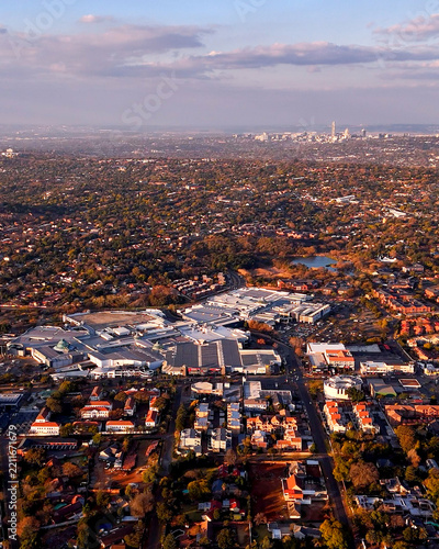Aerial view of Cresta Shopping Centre surrounded by the densely developed Northcliff suburbs, with the Johannesburg CBD skyline on the distant horizon in Johannesburg, Gauteng, South Africa.