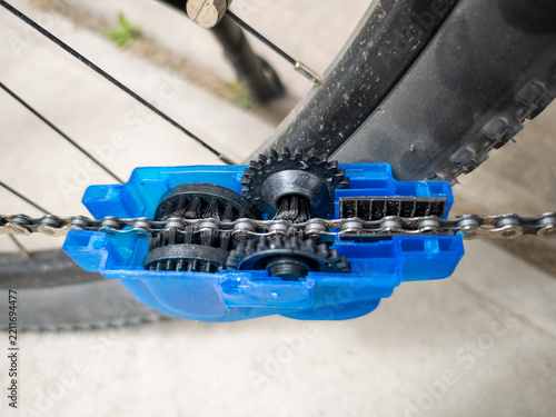 Bicycle chain cleaning tool with rotating brushes in action during bike maintenance