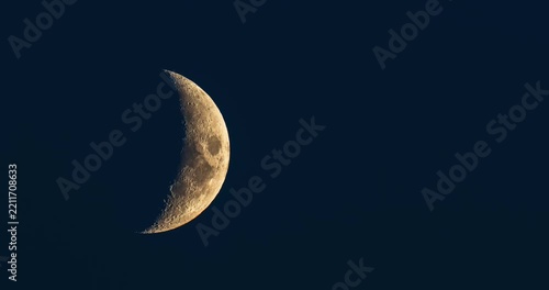 Beautiful detailed golden crescent moon moving in dark blue night sky time lapse video footage